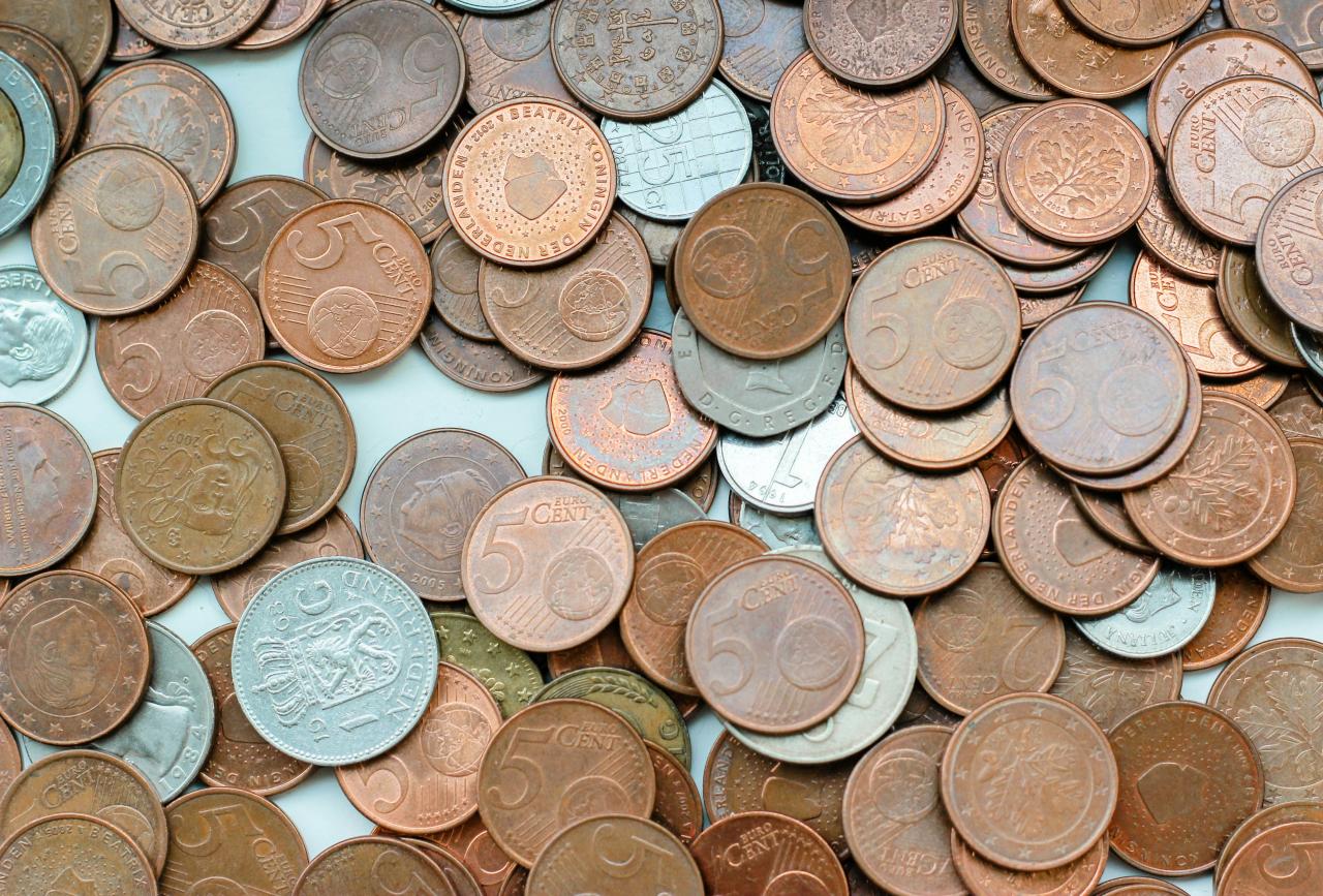 silver and gold coins on white surface